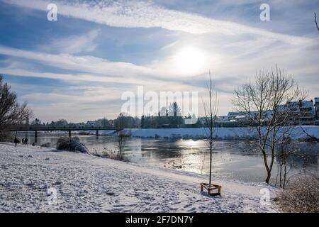 soleil se reflétant à la belle rivière gelée appelé werdersee au soleil journée d'hiver chaude et blanche avec digue enneigée à brême le soir Banque D'Images