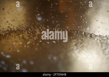 Bol de chant tibétain plein d'eau gros plan sur les gouttes d'eau, instrument de guérison sonore Banque D'Images