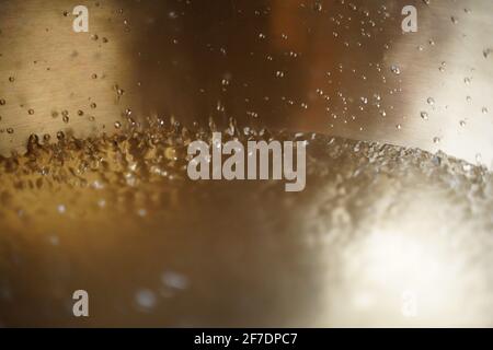 Bol de chant tibétain plein d'eau gros plan sur les gouttes d'eau, instrument de guérison sonore Banque D'Images