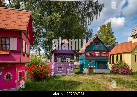 De petits modèles de maisons alsaciennes à colombages se tiennent sur une pelouse verte par une journée ensoleillée. France Banque D'Images