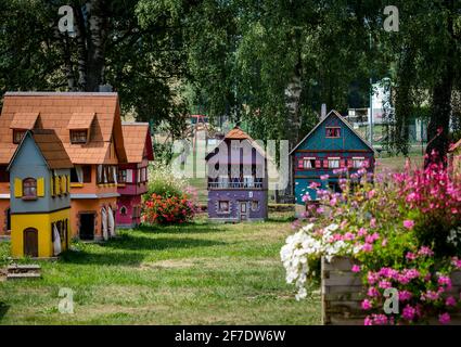 De petits modèles de maisons alsaciennes à colombages se tiennent sur une pelouse verte par une journée ensoleillée. France Banque D'Images