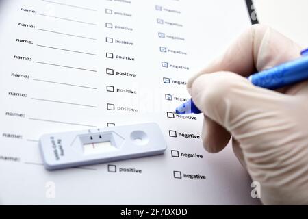 Mains d'un médecin ou d'une infirmière méconnaissable remplissant le formulaire de test du coronavirus. Test COVID-19. Formulaire de test médical pour le nouveau coronavirus Banque D'Images