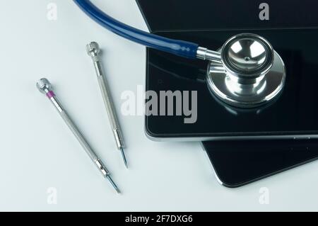 Stéthoscope, smartphone, tablette et tournevis. Concept de réparation et de service de smartphone. Concept un état de santé de l'appareil. Banque D'Images