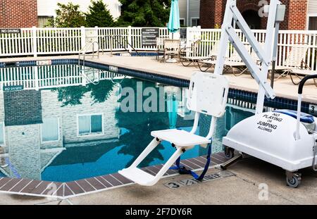 Une piscine extérieure dans la cour d'un hôtel est équipée d'un ascenseur pour personnes handicapées en fauteuil roulant. Banque D'Images