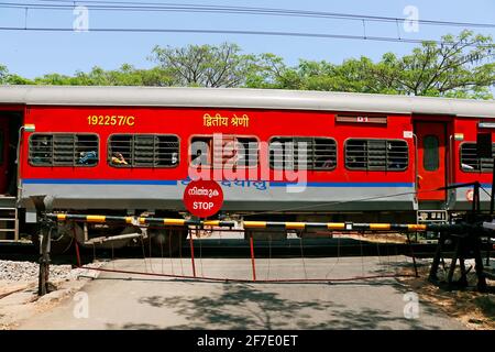 Kochi, Kerala, Inde -le 5 mars 2021 un train se déplaçant avec un support électrique à travers le chemin de fer indien fermé au niveau de la croix Banque D'Images