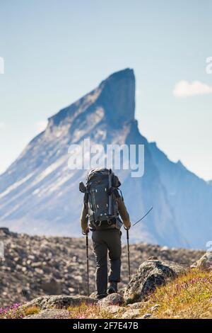 Vue arrière de l'arrière-sac à dos d'alpiniste sous Thor Peak, île de Baffin. Banque D'Images