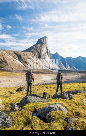 Les Backpackers se tiennent à la vue du mont Thor, île de Baffin, Canada. Banque D'Images