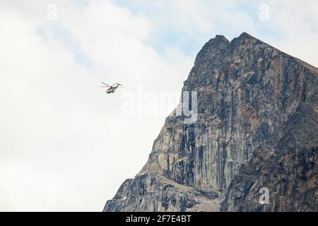 L'hélicoptère vole à côté de la falaise de montagne. Banque D'Images