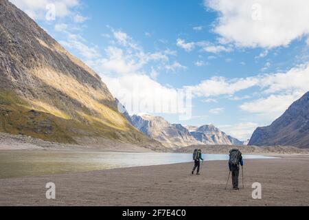 Vue arrière de deux hommes qui font de la randonnée dans le col d'Akshayak, parc national d'Auyuittuq Banque D'Images