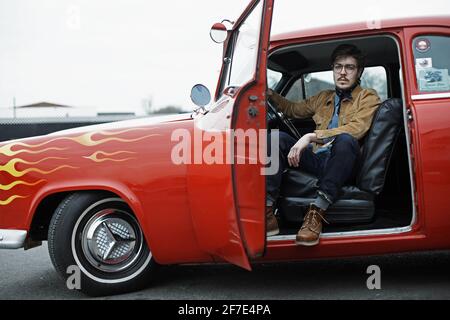 GRANDE-BRETAGNE / Angleterre / Jeune homme assis en 1954 Ford à la Hot Rod Night , Ace Cafe Londres. Banque D'Images