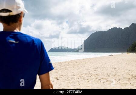 Homme serein regardant la vue sur la montagne tout en se tenant sur un plage à Hawai Banque D'Images