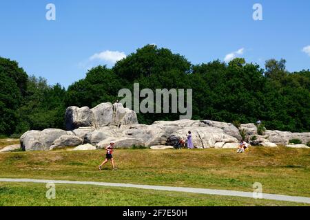 Homme passant devant Wellington Rocks sur Tunbridge Wells Common, Royal Tunbridge Wells, Kent, Angleterre Banque D'Images