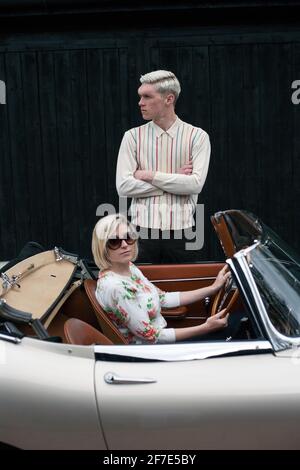 Un jeune couple stationné sur le côté et un homme debout près de leur cabriolet, 1964 Jaguar E Type série 1 Roadster, East Sussex, Royaume-Uni Banque D'Images