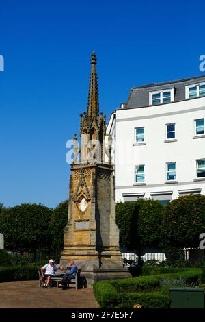 Hommes assis sur le banc devant le mémorial Edward Hoare, à l'angle du parc Culverden et du chemin St John's, Royal Tunbridge Wells, Kent, Angleterre Banque D'Images