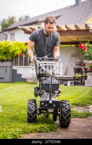 Machine à poser les câbles avec un opérateur utilisé pour poser les câbles des robots de tonte. Insertion du câble dans la terre comme câble guide pour la lawnm robotique Banque D'Images