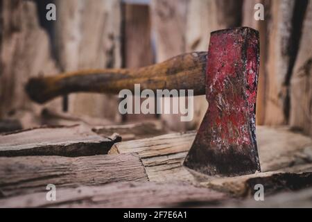 Hache de hachet étant coincé dans un tas de bois fendu de billes utilisées pour le feu. Concept de fabrication de grumes aux couleurs naturelles - Ax vu de l'avant et du côté. Banque D'Images