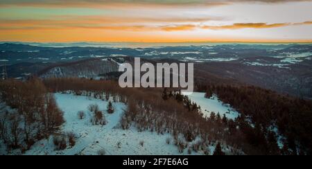 Vue en début de matinée depuis la colline de Slivnica au-dessus de Cerknica, juste quelques instants avant le lever du soleil. Belles montagnes couvertes de neige visibles au loin. Banque D'Images
