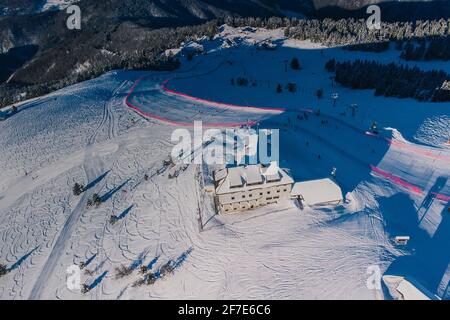 Panorama aérien de la piste de ski de Krvavec en Slovénie, visible également un parcours de ski entre la clôture rouge. Banque D'Images