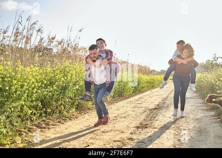 une famille heureuse traverse la campagne au printemps Banque D'Images