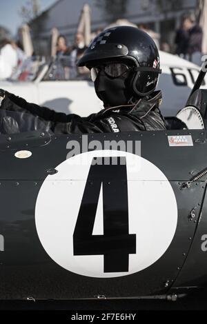 Pilote de course avec masque facial, lunettes et casque au Goodwood Revival, West Sussex, England.Man portant des lunettes de course et un casque de sécurité. Banque D'Images