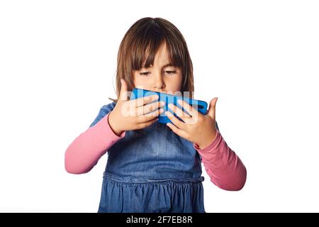 mauvaises habitudes de la jeune fille de 4 ans. regarder le téléphone avec concentration. concept de problème avec les médias sociaux, toxicomanie problèmes d'enfant Banque D'Images