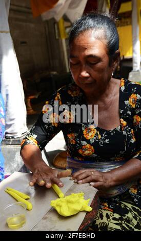 Femme balinaise préparant une offrande faite à la main appelée Jajan Suci ou Palegembai dans un temple hindou à Bali, en Indonésie. Banque D'Images