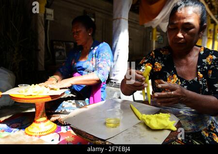 Femme balinaise préparant une offrande faite à la main appelée Jajan Suci ou Palegembai dans un temple hindou à Bali, en Indonésie. Banque D'Images