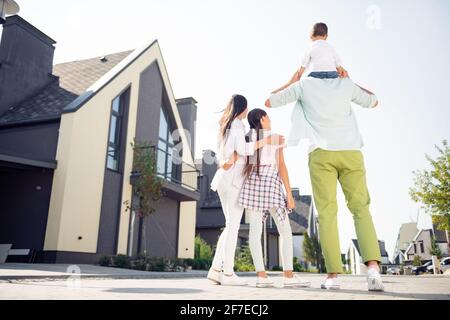 Arrière de la carrosserie pleine longueur derrière la vue de Nice adorable famille marchant s'amuser à jouer papa portant son fils petite ville à l'extérieur Banque D'Images