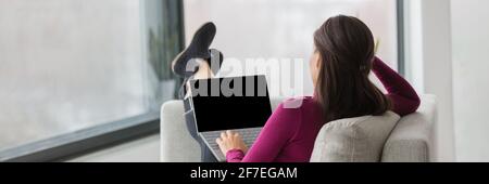 Étudiant à la maison, travaillant à distance et regardant un séminaire virtuel en ligne. Femme de derrière pieds de détente sur le canapé dans la salle de séjour, étude facile Banque D'Images