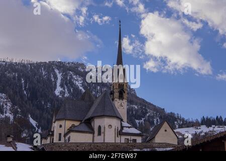 Église sur une colline dans le centre de la ville de Moena dans les dolomites italiens dans la vallée de Fassa par une chaude journée d'hiver. Banque D'Images