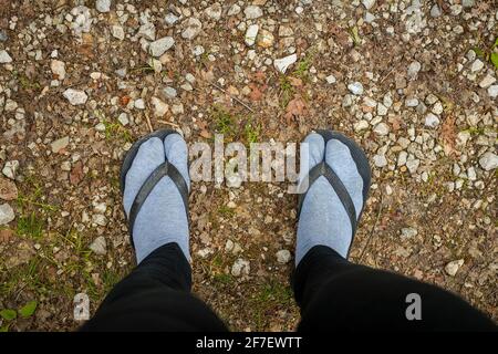 Victime de la police de la mode - portant des sandales sur les pieds recouverts de chaussettes grises. Une chose terrible à faire. Banque D'Images