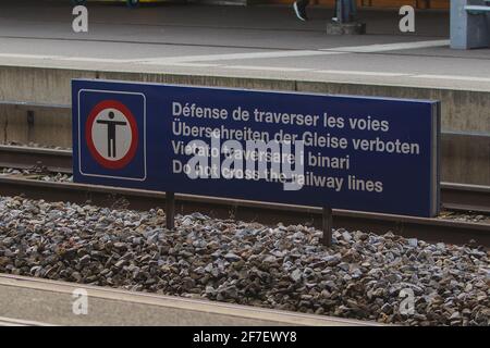 Panneau de signalisation pour empêcher les personnes de traverser les voies ferrées, écriture blanche sur tableau bleu avec des écrits dans différentes langues européennes. Banque D'Images