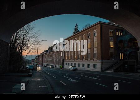 Vue sur la rue dans le quartier de Flon à Lausanne, suisse en heure bleue en hiver. Quelques voitures sur la route à côté du bâtiment de brique rouge et d'und Banque D'Images