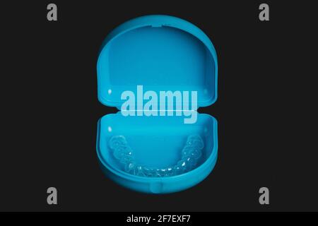 Mallette de transport bleue pour dispositif de retenue orthodontique en plastique transparent isolé sur noir. Dispositif de retenue pour l'alignement des dents. Banque D'Images