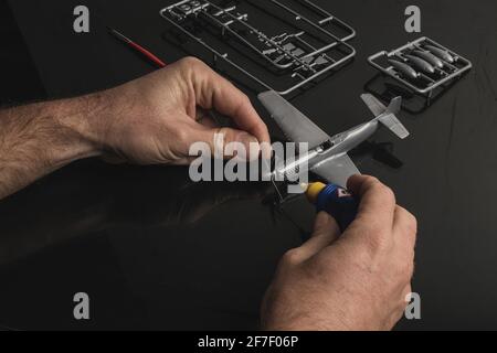 Détail de l'assemblage du kit de résine d'avion modèle plastique avec colle. Colle de ciment utilisée pour coller les parties de l'avion modèle en plastique ensemble. Banque D'Images