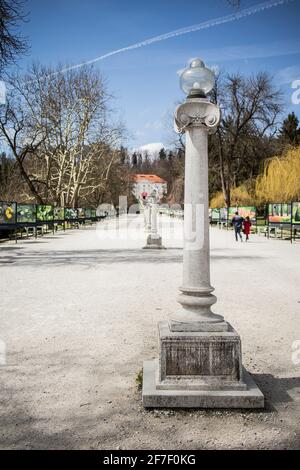 Jakopicevo strehajalisce, une passerelle dans le parc Tivoli ou les jardins de ljubljana avec des lumières de rue millésimes et un château en arrière-plan. Banque D'Images