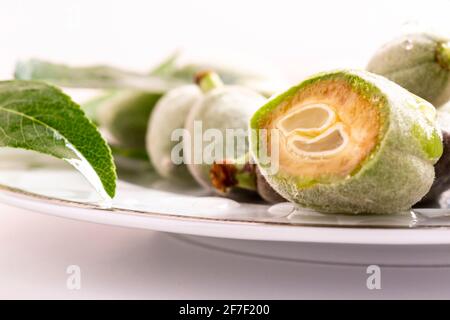 Les amandes vertes fraîches se rapprochent de l'assiette. Banque D'Images