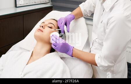 Des injections de beauté dans un beau visage de femme, le lissage des rides imitant autour des yeux en utilisant la biorevitalisation Banque D'Images