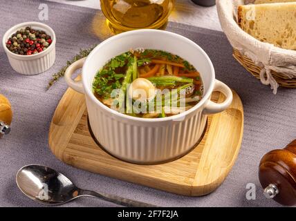 Soupe de poulet aux légumes dans un bol blanc servi avec de la fumée œuf de caille Banque D'Images