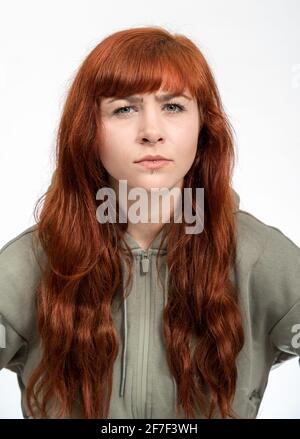 Portrait d'une fille avec des cheveux rouges sur fond blanc je regarde sceptique Banque D'Images