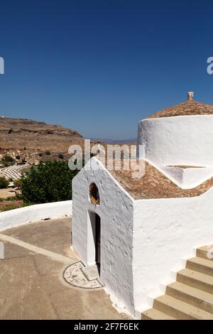 La chapelle Saint George Pachymachiotis à Lindos, sur Rhodes, Grèce. La chapelle grecque orthodoxe blanche est vue sous un ciel bleu clair. Banque D'Images