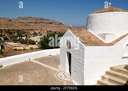La chapelle Saint George Pachymachiotis à Lindos, sur Rhodes, Grèce. La chapelle grecque orthodoxe blanche est vue sous un ciel bleu clair. Banque D'Images