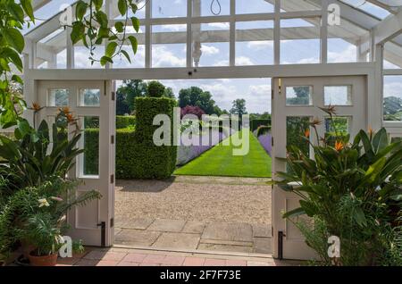 Houghton Hall Gardens en été, Norfolk, Royaume-Uni; vue depuis les portes ouvertes de la serre jusqu'au jardin. Banque D'Images