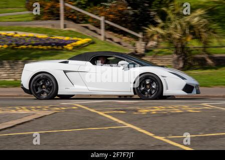 Lamborghini Gallardo LP 560-4 Spyder supercar sport en passant par Cliff Gardens avec des fleurs lumineuses. Voiture de sport de cabriolet blanc à Southend Banque D'Images
