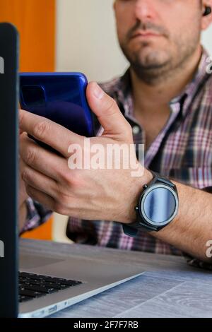 Gros plan d'un homme devant un smartphone, en faisant une visioconférence. Concept de télétravail à domicile. Concept de télétravail à domicile. Banque D'Images