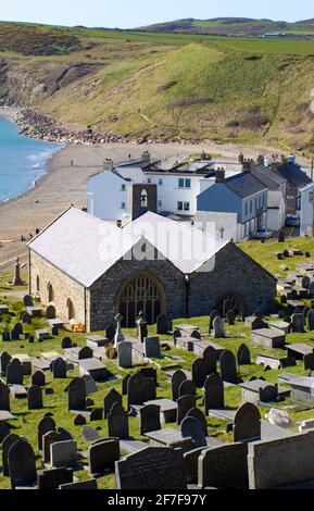 Aberdaron, pays de Galles. Église paroissiale de Saint Hywyns. Vue panoramique sur la baie et la plage, avec l'église historique de pèlerin en premier plan. Banque D'Images