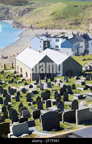 Aberdaron village, pays de Galles. Église historique de Saint Hywyns. Photo en grand angle avec la magnifique baie, et la plage comme arrière-plan. Vue portrait. Banque D'Images