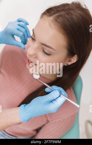 Vue verticale du dessus photo d'une jeune femme qui se fait dentaire vérification par un dentiste méconnaissable Banque D'Images