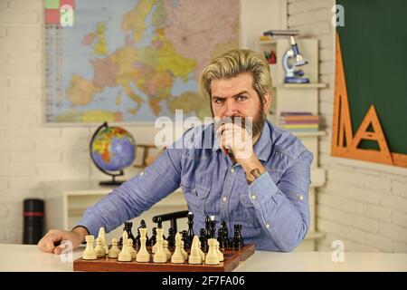 Concept de stratégie. Professeur d'école. Faites votre propre pensée de manière indépendante. Leçon d'échecs. Jeu de société. Homme intelligent jouant aux échecs. Figures sur le plateau d'échecs Banque D'Images