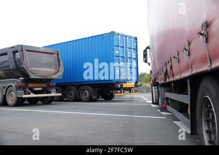 Trois types et couleurs de camions différents dans le parking. Tripper, camion-conteneur et camion avec bâche Banque D'Images